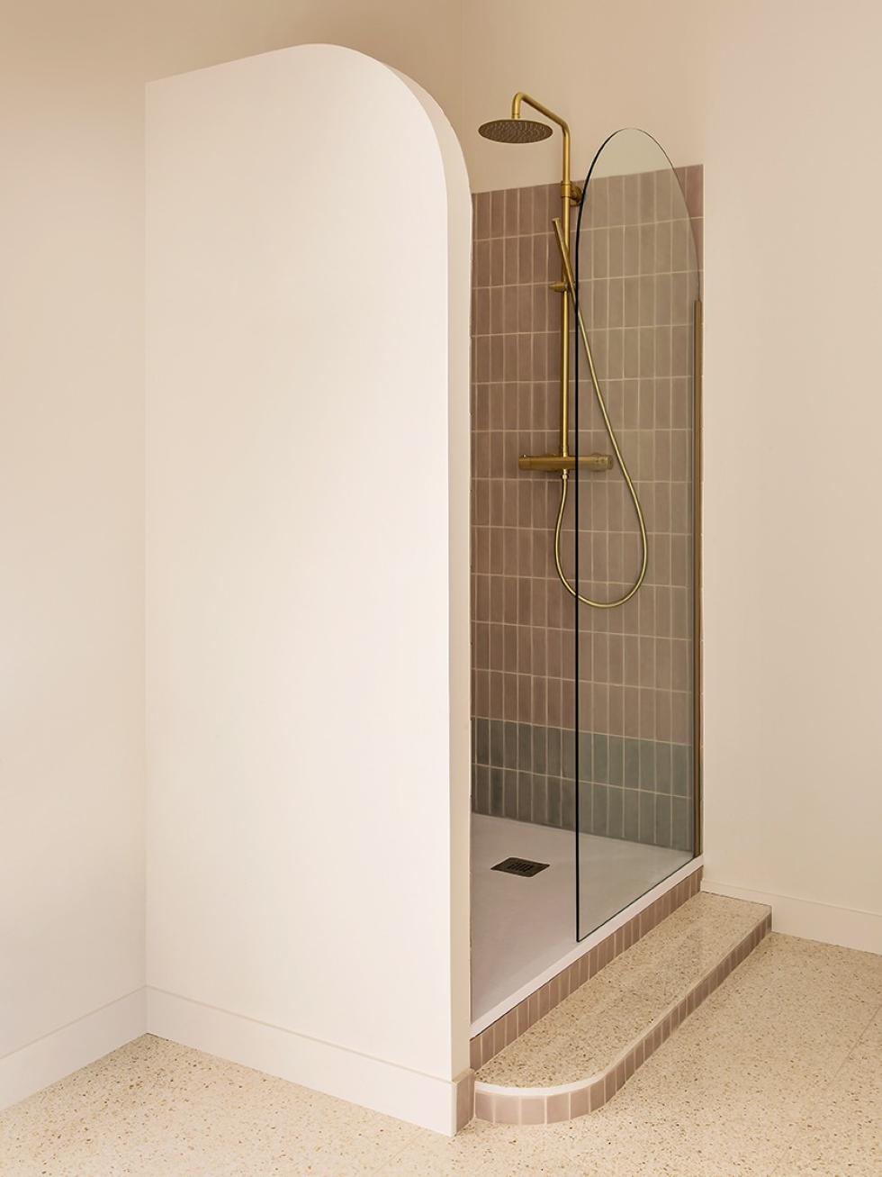 Cabine de douche avec robinetterie en laiton et détails arrondis